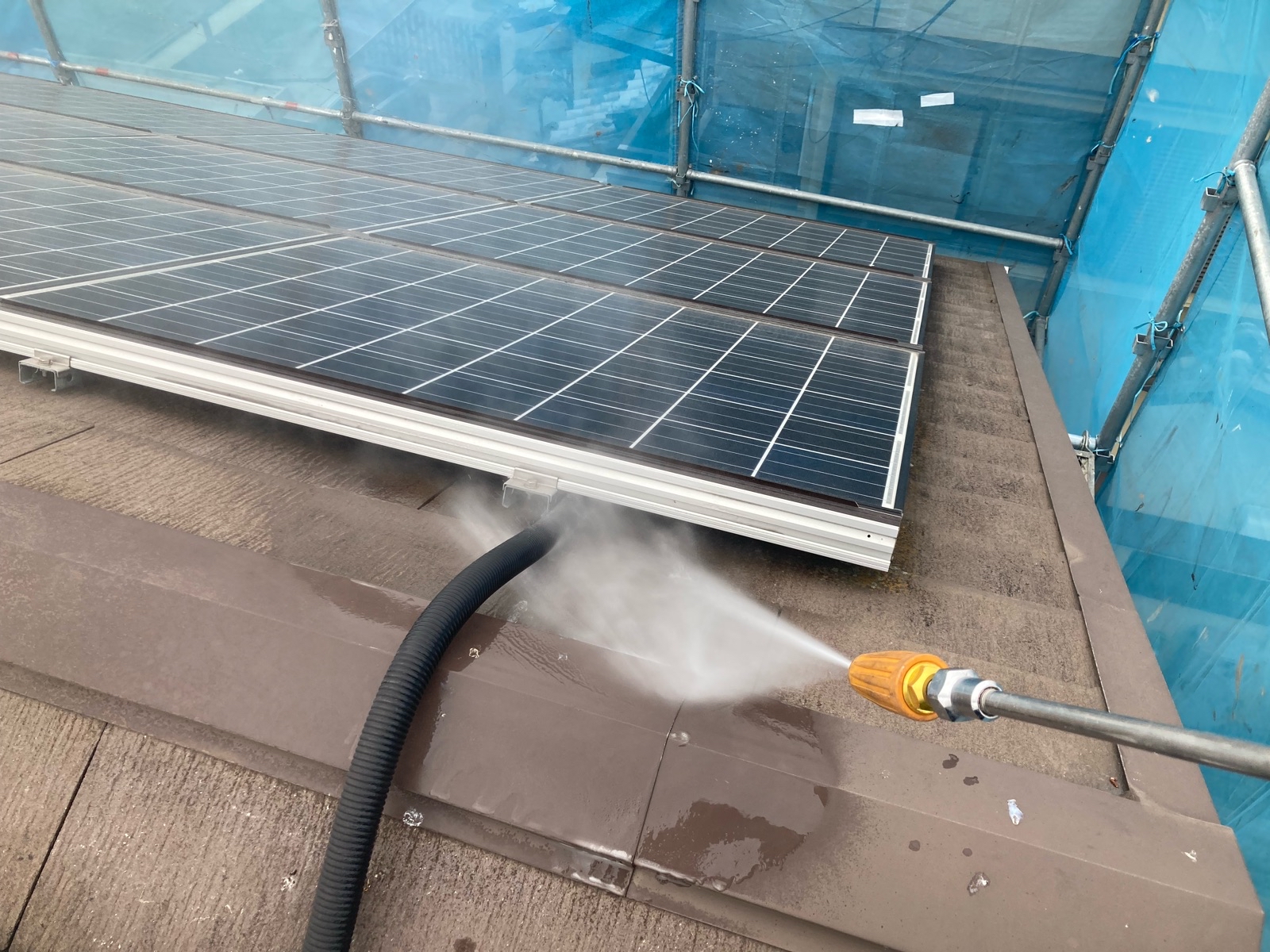 一般戸建て住宅の屋根を塗装前に洗浄する様子