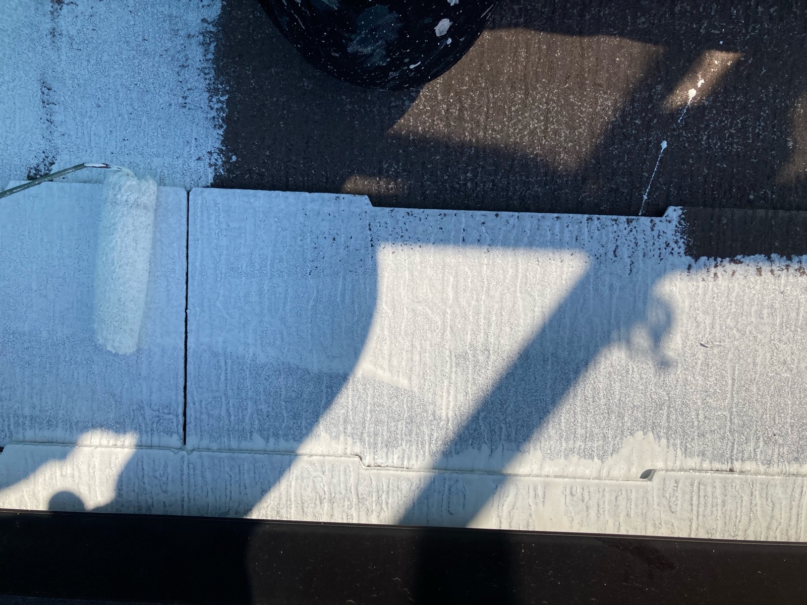 一般戸建て住宅の屋根の下塗りをする様子